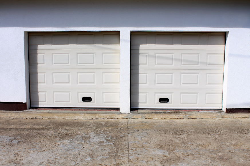 Two-door garage with a driveway with cracks